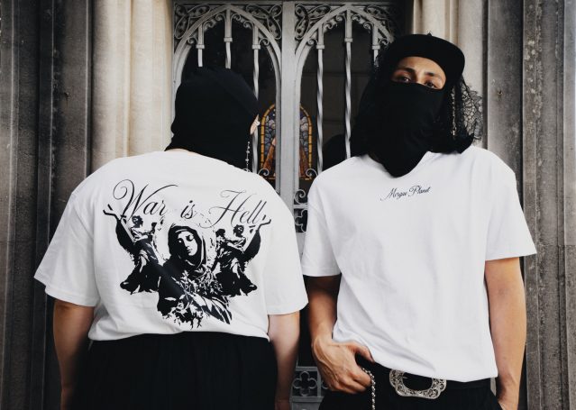 Dos personas de espaldas con camisetas blancas, una con un diseño gráfico en la parte de atrás.