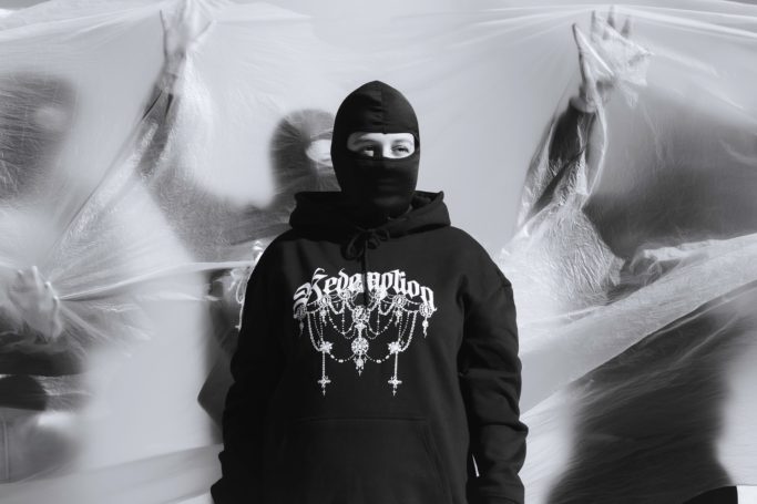 Foto artística modelo principal morgue planet con sudadera redemption de lettering y Rosarios cayendo 