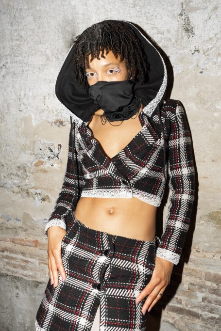 Modelo Morgue Planet con conjunto de dos piezas blazer con capucha y falda de punto con acabados de encaje.